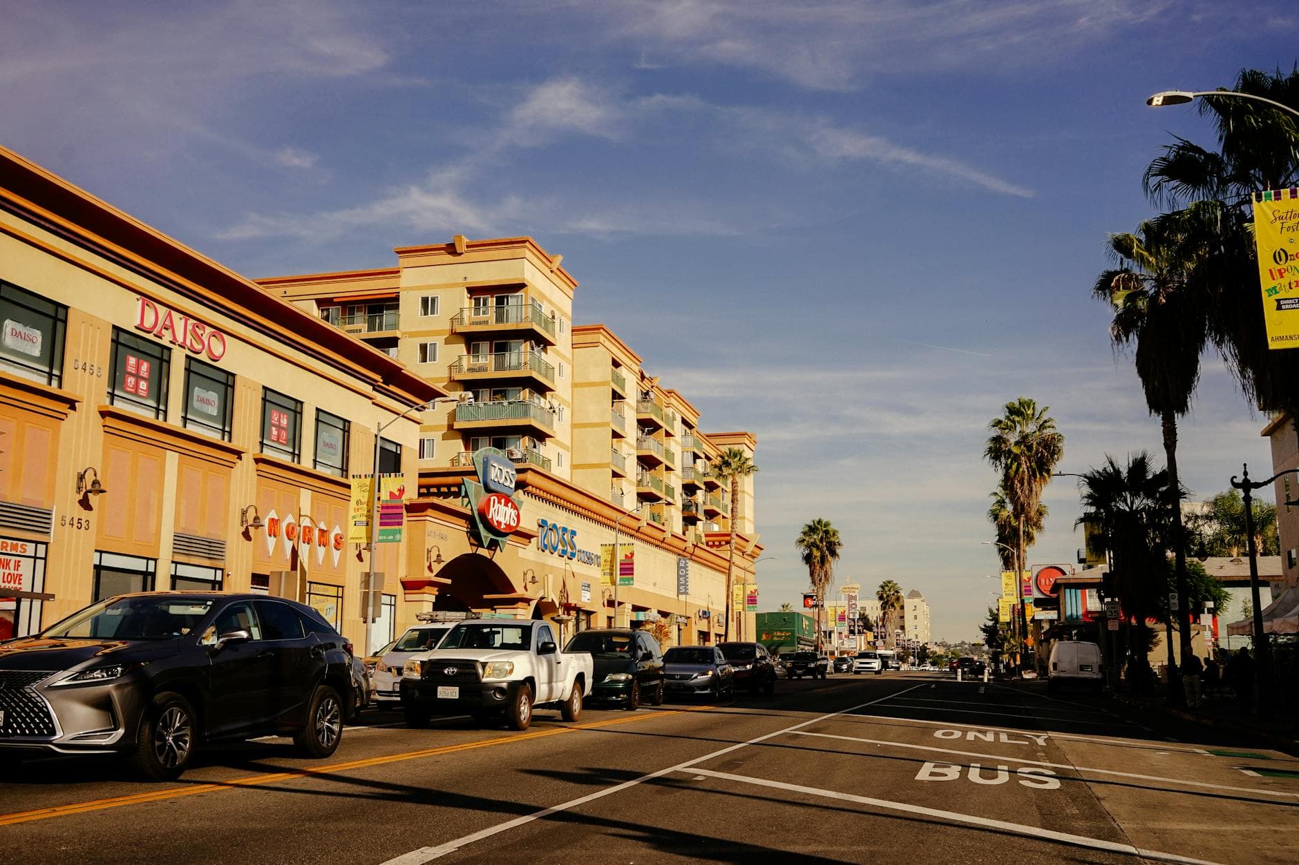 Vibrant city street scene showcasing traffic and popular stores on a sunny day.