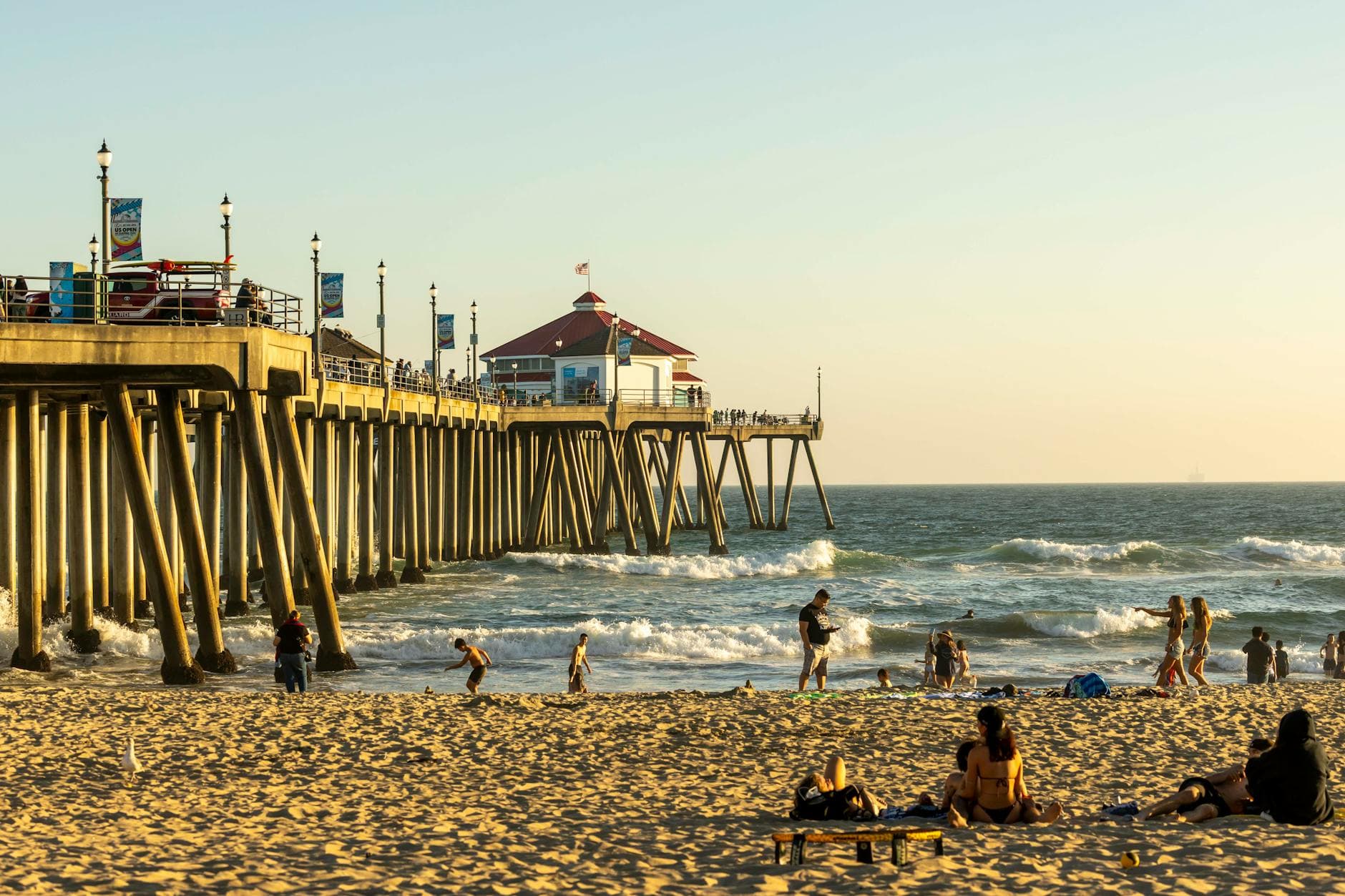 Relaxing summer day at Huntington Beach Pier with people enjoying the sun and surf.
