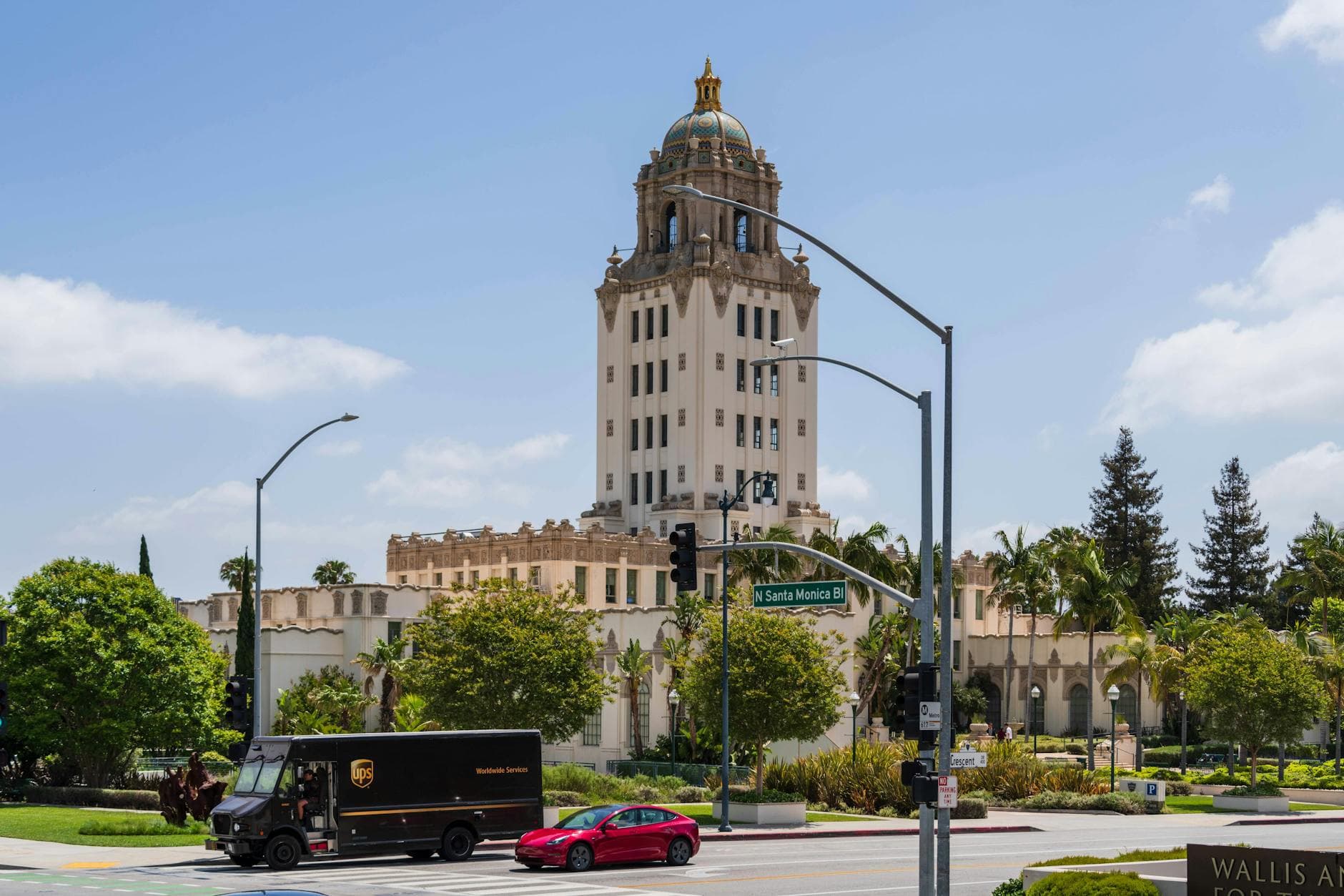 Stunning view of Beverly Hills City Hall from Santa Monica Blvd, showcasing Spanish Revival architecture and bustling street below.