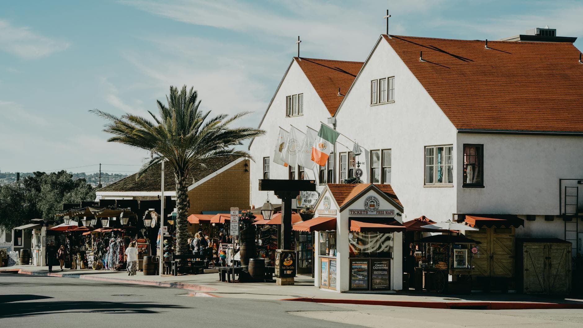 A sunny day at a historic market street in San Diego Old Town with shops and palm trees.