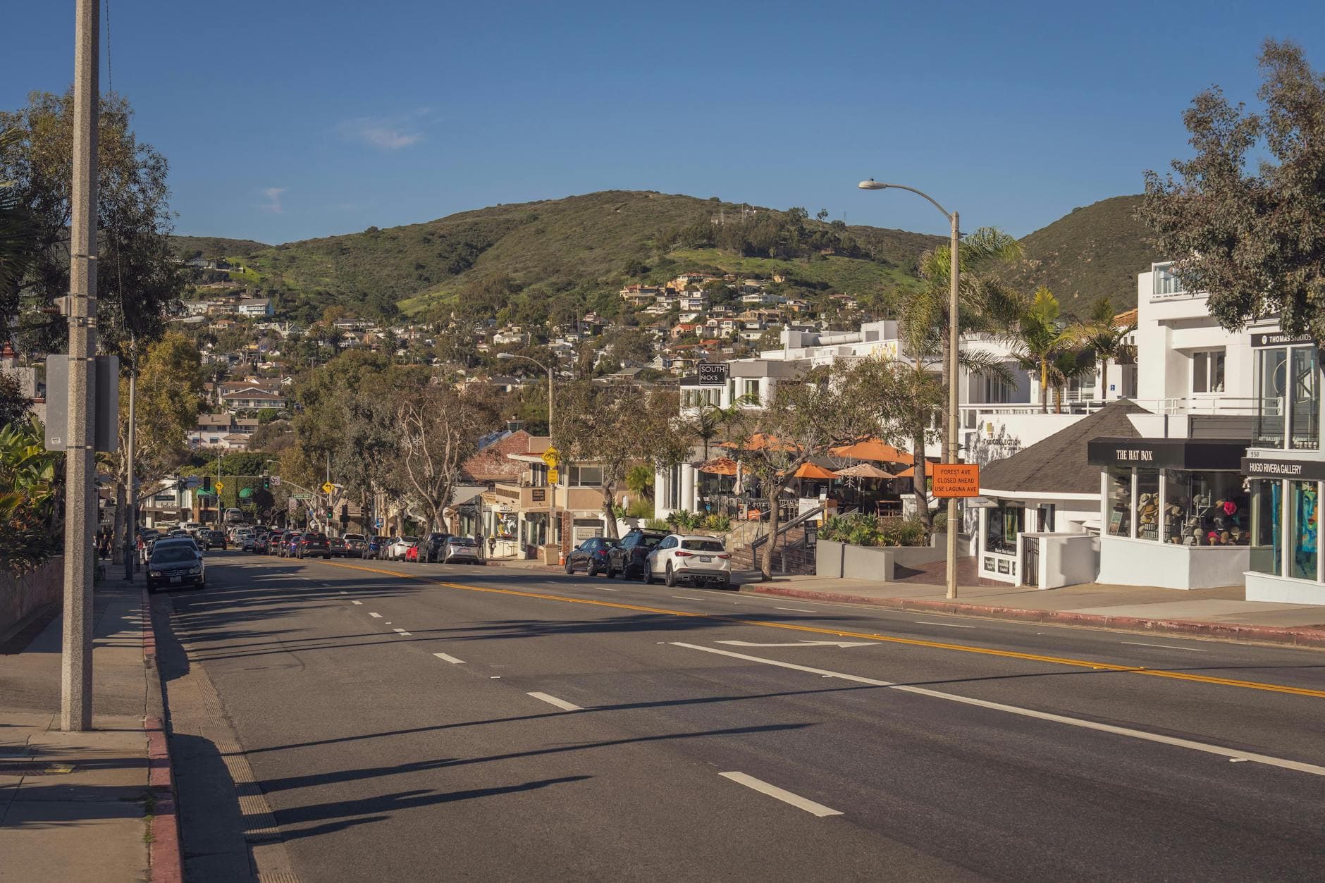 A picturesque street view of Laguna Beach, California, under a clear blue sky